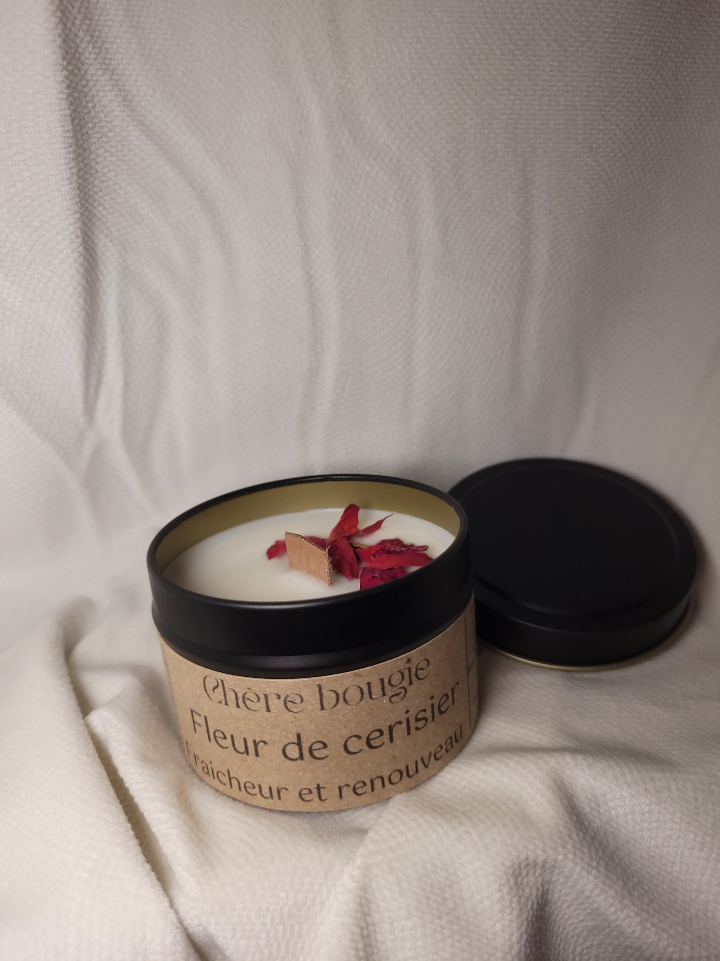 Bougie artisanale fleur de cerisier allumée, diffusant une lumière chaleureuse et une ambiance relaxante.