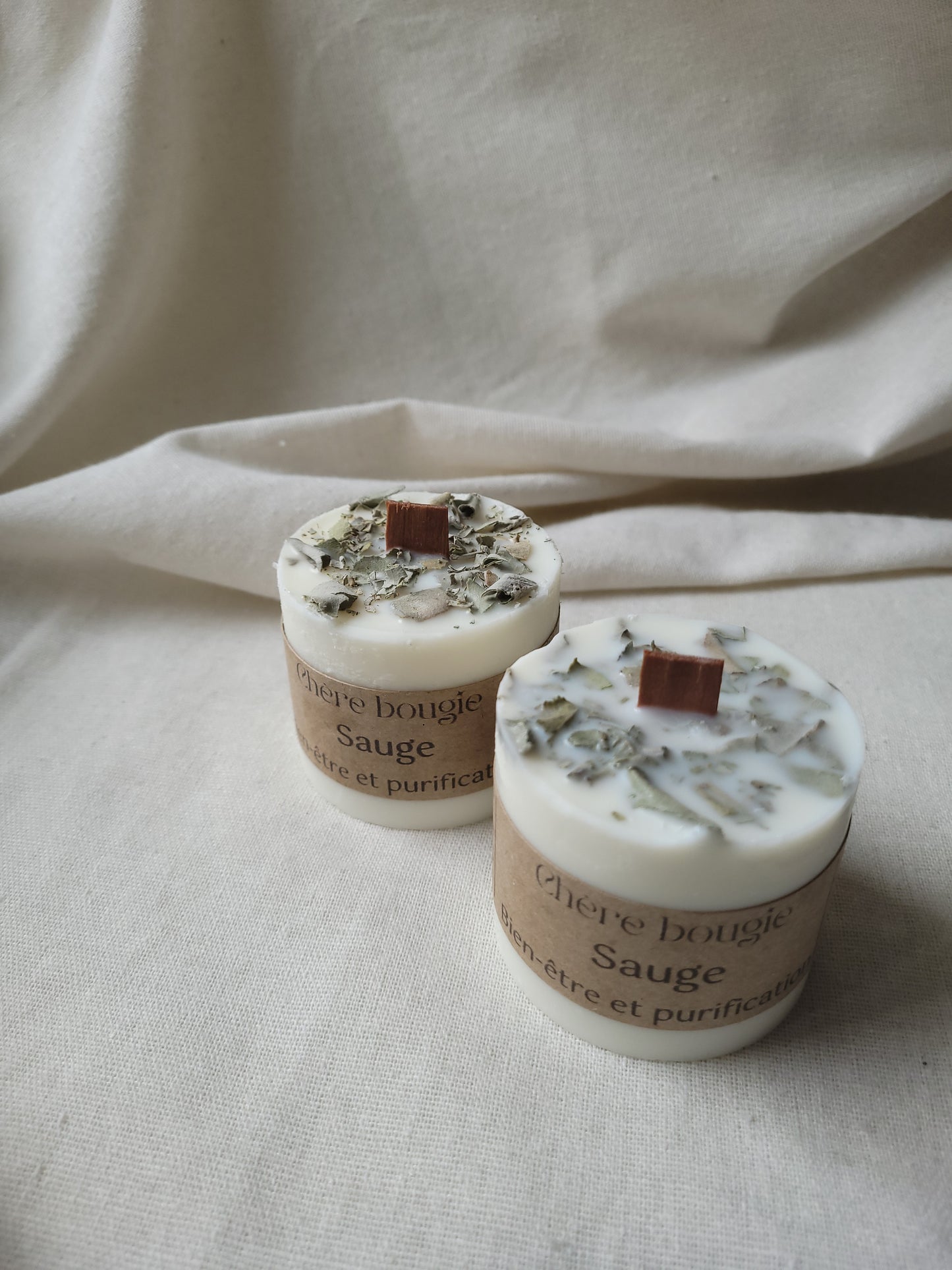 Bougie artisanale allumée diffusant un parfum apaisant de sauge dans un cadre intérieur cosy, créant une atmosphère sereine et relaxante.