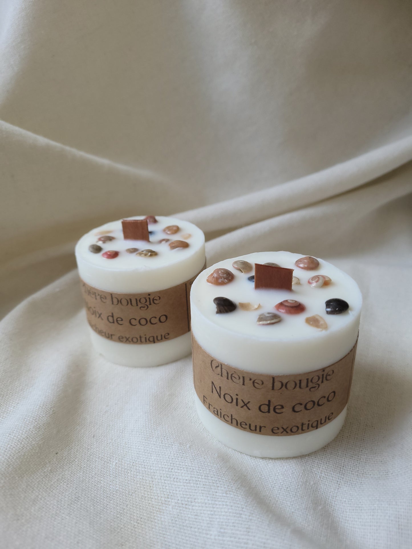 Bougie artisanale parfumée à la noix de coco, montrant la cire fondue avec une lumière douce qui éclaire l’espace.