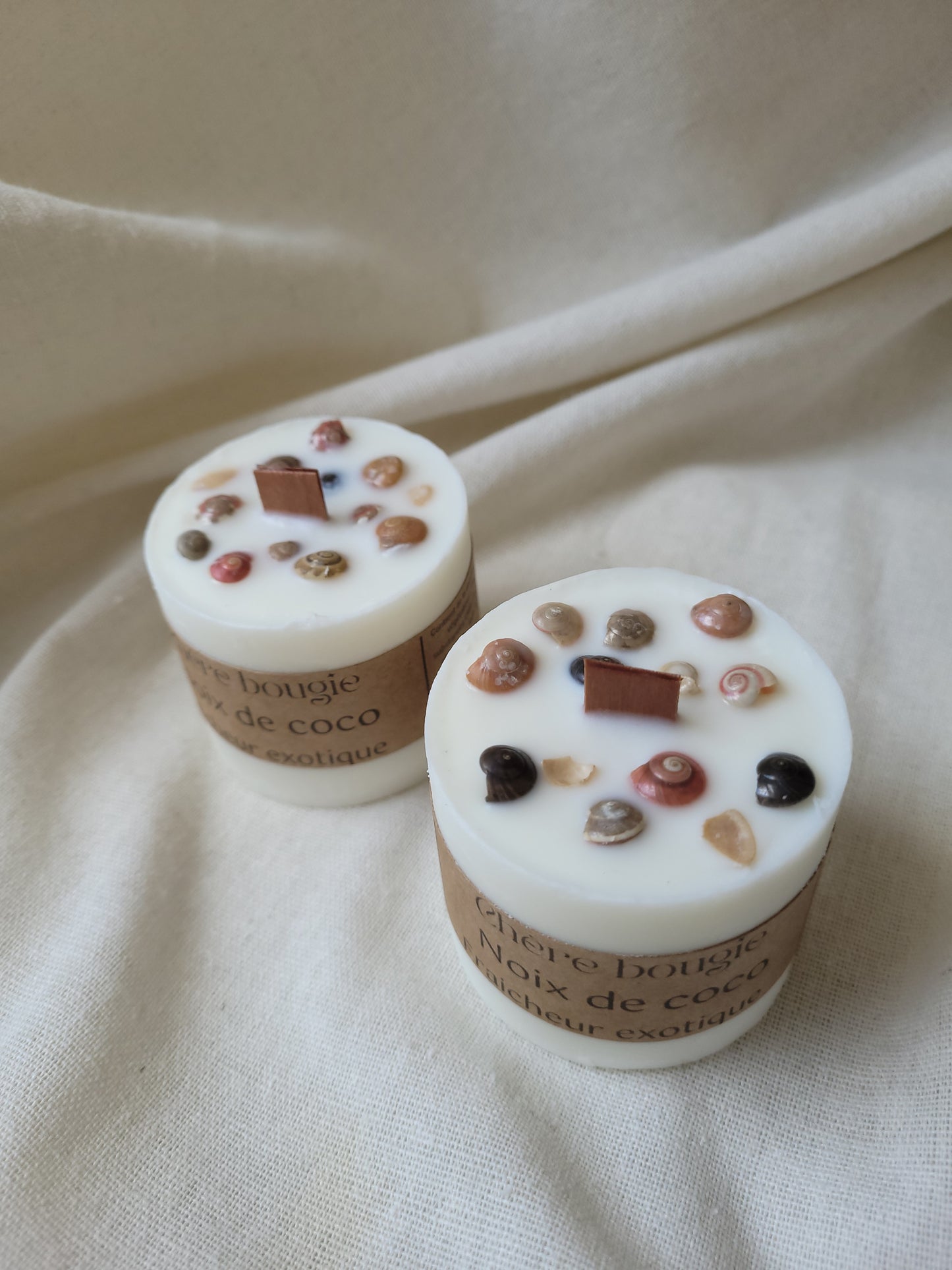 Vue artistique de la bougie à la noix de coco sur une surface résistante à la chaleur, mettant en avant son esthétique minimaliste.