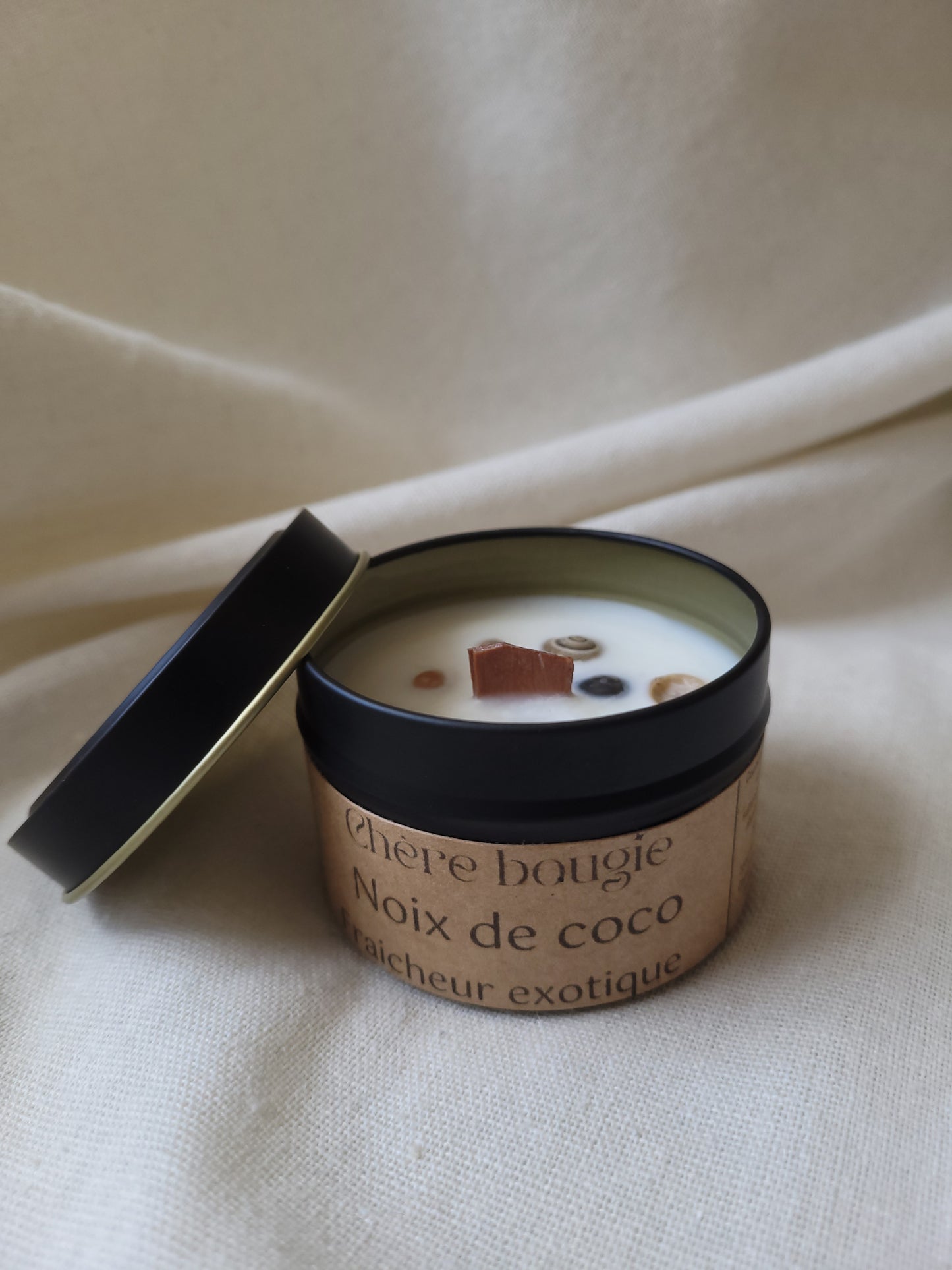 Photo de la bougie artisanale Chère Bougie dans son contenant en métal noir élégant, parfumée à la noix de coco